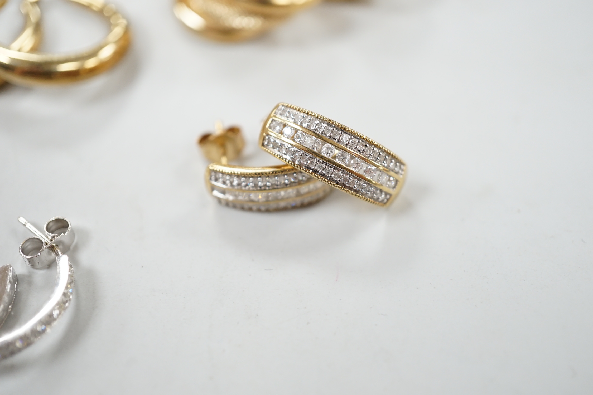 Two modern pairs of 9ct hoop or half hoop earrings and two pairs of 9ct and diamond chip set earrings including white gold, gross weight 10.9 grams.